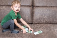 concentrated-caucasian-child-casual-clothes-holds-one-hundred-euros-his-hands-counts-money-sof...jpg