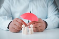 businessman-s-hand-is-holding-umbrella-wooden-family.jpg