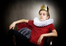 57823878-crowned-boy-sitting-in-an-armchair.jpg